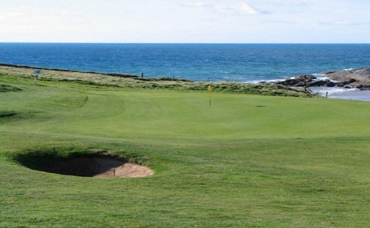 A bunker hazard by a green at Mullion golf course